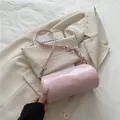 Rosafarbene zylindrische Umhängetasche mit Kettendetails und Relief auf glänzendem Leder - Rosa