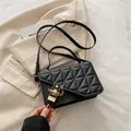 Chic black quilted crossbody bag with golden geometric lock and adjustable strap - Black