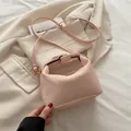 Pink snake embossed pillow handbag with gold metal clasp and adjustable shoulder strap - Pink