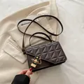 Sac bandoulière matelassé marron foncé avec chaîne dorée sur fond de blazer beige - Marron