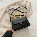 Elegante schwarze Umhängetasche mit Eidechsenmuster-Leder und goldfarbenem Metallgriff - Schwarz