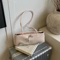 Lichtroze okseltas met zilveren strikjes en een zachte matte lederen textuur - Zonder hanger / Roze