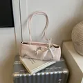 Pink ribbon shoulder bag with faux leather texture and elegant pearl bow accents - With Pendant / Pink