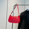 Red Saffiano leather baguette underarm bag with minimalist half-moon shape and gold hardware - Red