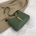 Minimalistische donkergroene matte leren okseltas met gouden kettingriem op blazer - Groen