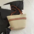 Gevlochten strooien emmer tas met etnische patroonband en bruin lederen riem - Etnische Bandstijl / Beige