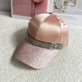 Detail of pink satin baseball cap with glitter brim and rhinestone belt buckle accent - Pink