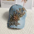 Detail einer hellblauen Jeans-Baseballkappe mit goldener Blumenstickerei und Strass - Hellblaues Denim (2# Denim)