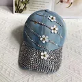 Detailed view of light blue denim baseball cap with crystal rhinestones and 3D floral accents - Adult, Adjustable / Medium Blue Denim