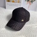 Detail of black houndstooth baseball cap featuring a sparkling gold rhinestone M logo - Black