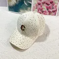 Detailed view of cream rhinestone baseball cap with a gold metal C logo on front - Off-white With C Mark / Adult, Adjustable