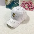 Dettaglio del cappellino bianco con strass brillanti e logo metallico a forma di C - Bianco Con Logo C / Adulto, Regolabile