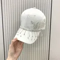 White lace baseball cap featuring sparkly rhinestone butterfly and hanging tassel fringes - One Size(Adjustable) / Off White