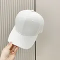 White jacquard baseball cap with textured pattern shown in a hand-held lifestyle shot - Adult, Adjustable / White