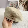 Detail von cremefarbenem Barett mit dezentem Silberglitzer und zwei braunen Lederschnallen - L (56-60cm) / Beige