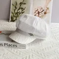 Detail einer weißen Spitzen-Schirmmütze mit silberner Schnalle und Schleifenband - M (56-58cm) / Weiß