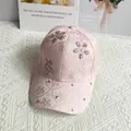 Detalle de gorra de béisbol de satén rosa con flores en relieve y brillantes pedrería - Ajustable / Rosa