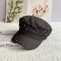 Dettaglio del berretto militare in denim scuro con borchie metalliche dorate in stile rock - M (56-58cm) / Nero con strass dorati