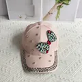 Close-up of pink denim baseball cap with crystal bow and rhinestone-studded brim - Bow / Pink