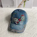 Close-up of light blue denim baseball cap with rhinestone bow and silver crystal studs - Bow / Denim Blue