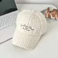 Nahaufnahme der weißen Plüsch-Baseballkappe mit brauner Stickerei auf weißem Tisch - Verstellbar / Weiß
