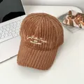 Detailansicht der карамеllbraunen Plüsch-Baseballkappe mit weißer Buchstabenstickerei - Verstellbar / Kaffeebraun