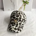 Nahaufnahme der Teddy-Fleece-Baseballkappe mit Leopardenmuster und goldenem TR-Logo - Verstellbar / Schwarz-Weiß-Leopardenstil / Weiß