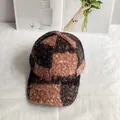 Detalle de gorra de béisbol de felpa teddy a cuadros con textura cálida y patrones marrones - Ajustable / Rosa