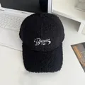 Detail of black faux shearling baseball cap with Balance embroidery on laptop desk - Adjustable / Black