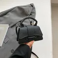 Elegante borsa nera a mano strutturata a clessidra con finiture in metallo dorato - Nero