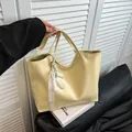 Minimalistische lichtgele leren tote bag met elegant parel kant ornament op een boek - Geel