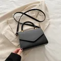 Bolso bandolera negro chic con solapa tejida y elegantes detalles en tono dorado - Negro
