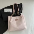 Pink floral embroidered tote bag with textured fabric and golden ring handles for women - Pink