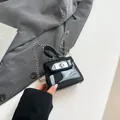 Minibolso trapezoidal de charol negro con cadena de plata y diseño elegante mujer - Negro