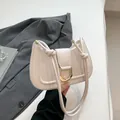 Elegante bolso de silla de montar crema con hebilla en U dorada y correa anudada - Blanco