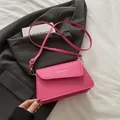 Bolso de hombro en cuero PU rosa con logo dorado sobre una chaqueta gris oscuro - Fucsia