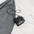Mini crossbody tas in zwart met witte stippen en een strikje op de bovenste flap - Zwart