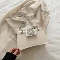 Elegant cream rhinestone flap bag with silver chain strap shown against a beige blazer - White