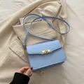 Sac bandoulière carré bleu clair avec texture en cuir fin et boucle en métal doré élégante - Bleu