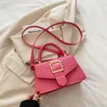 Bolso bandolera fucsia con textura trenzada y hebilla dorada para mujer moderna - Rosa