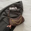 Dark brown faux crocodile underarm bag with gold chain and vintage studs on a blazer - Brown