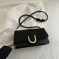Black snake-pattern woven shoulder bag with gold U-shaped buckle and rope strap - Black