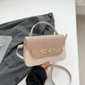 Bolso elegante bicolor en crema y marrón con cierre metálico en un entorno moderno - Estilo Patchwork Blanco Crema y Marrón / Blanco