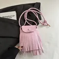 Rosafarbene Umhängetasche mit Fransen und mattem Finish auf minimalistischem Hintergrund - Rosa