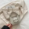 Mini Umhängetasche in Creme mit silberner Schleifenschnalle und eleganter Metallkette - Weiß