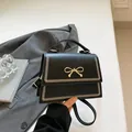 Bolso bandolera negro con lazo dorado y elegante detalle de costura en V frontal - Negro