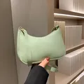 Hellgrüne halbmondförmige Schultertasche aus Leder mit schicken Goldbeschlägen - Grün