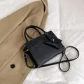 Elegante schwarze Umhängetasche mit Mini-Umschlagtasche und goldenen Metalldetails - Schwarz