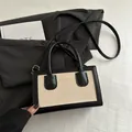 Beige canvas tote with black leather trim and adjustable strap in a minimalist style - Black