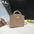 Minimalist beige crossbody bag with deer charm and crocodile texture in a chic setting - Khaki